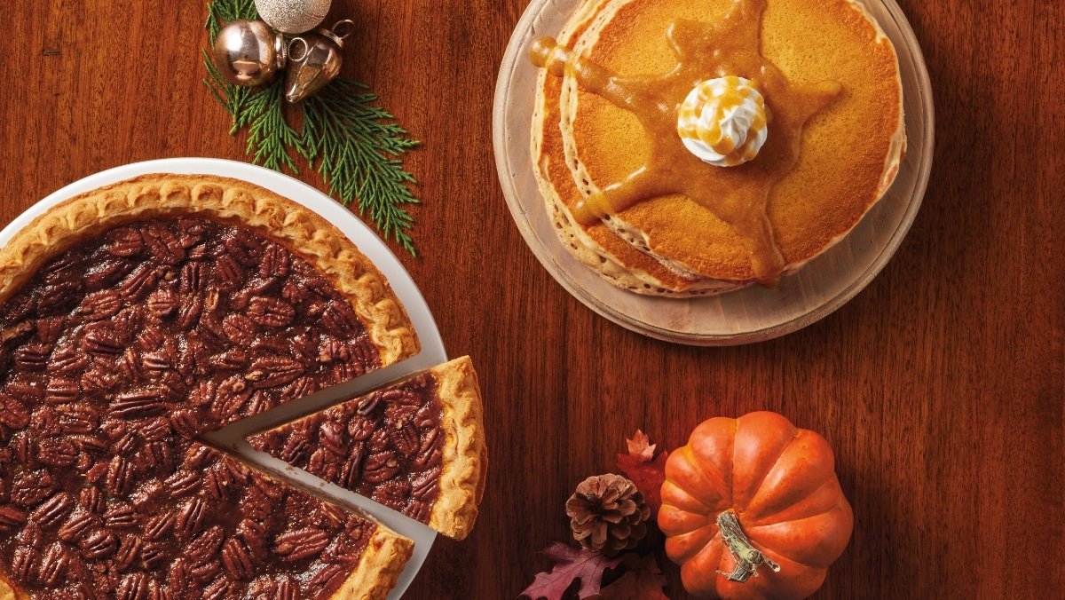 Food & Beverage 2 - 50_50 A pecan pie with a slice missing, a stack of pancakes drizzled in caramel sauce, and a small pumpkin adorn the wooden table—each as precise as creations from top-notch 3D printing services.