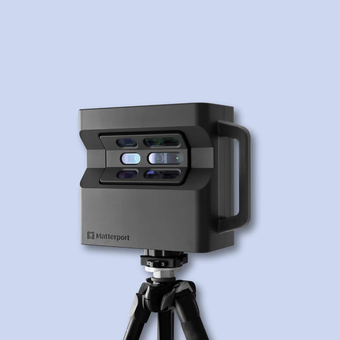 A black Matterport 3D camera mounted on a tripod, positioned against a plain light blue background.